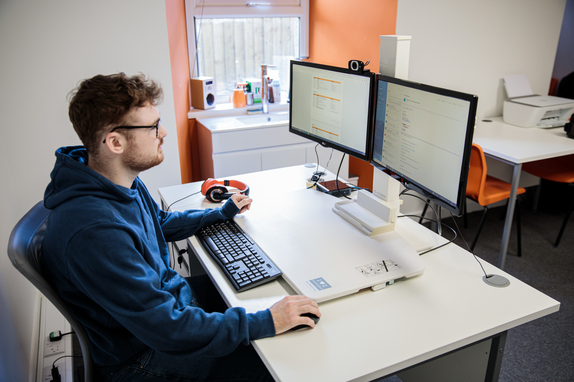 A man sat at a desk on a computer working